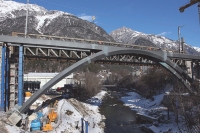 View of the new steel arch bridge in front of the existing lattice girder bridge, during construction